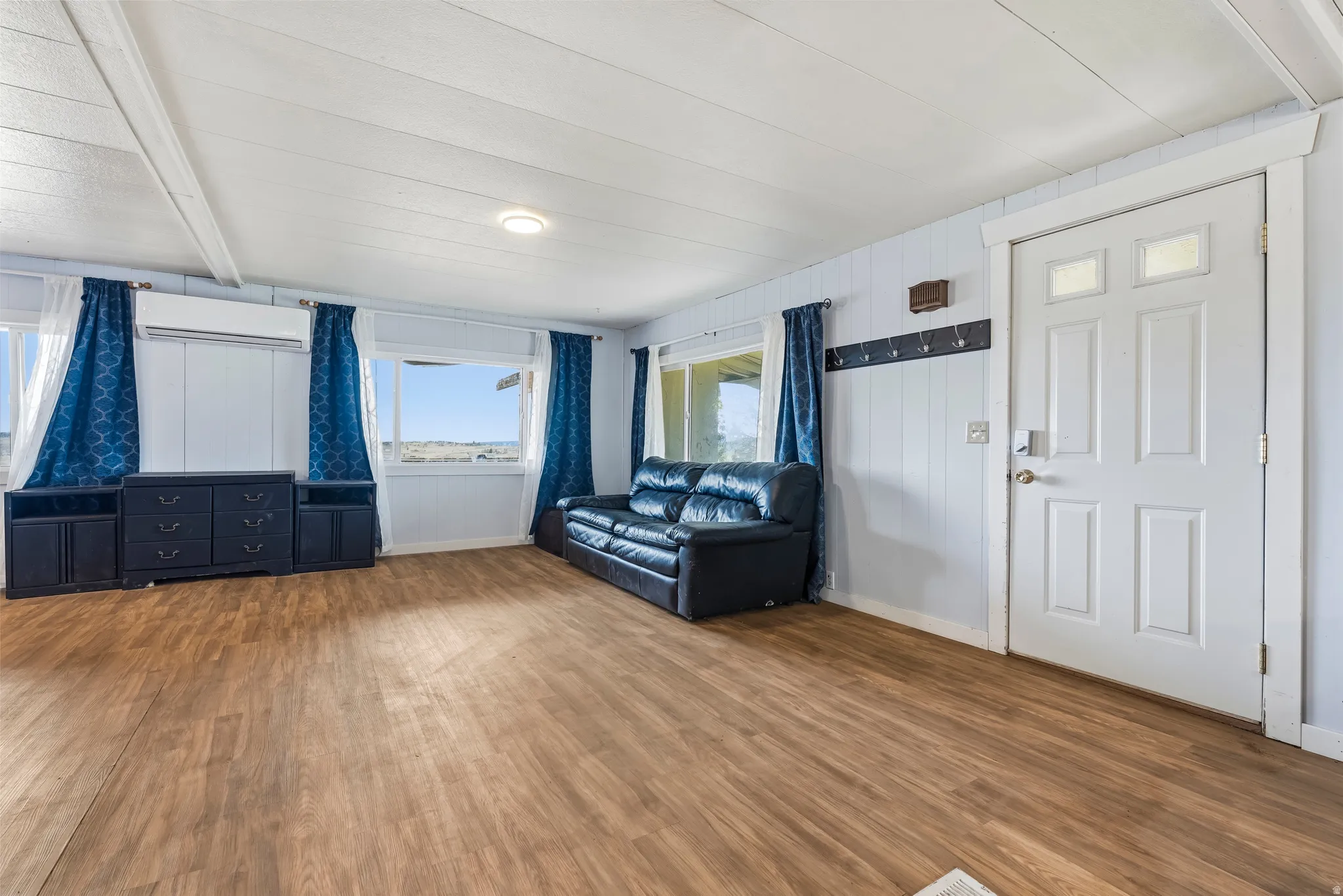 Unfurnished living room featuring wood finished floors and a mini split for heating / cooling