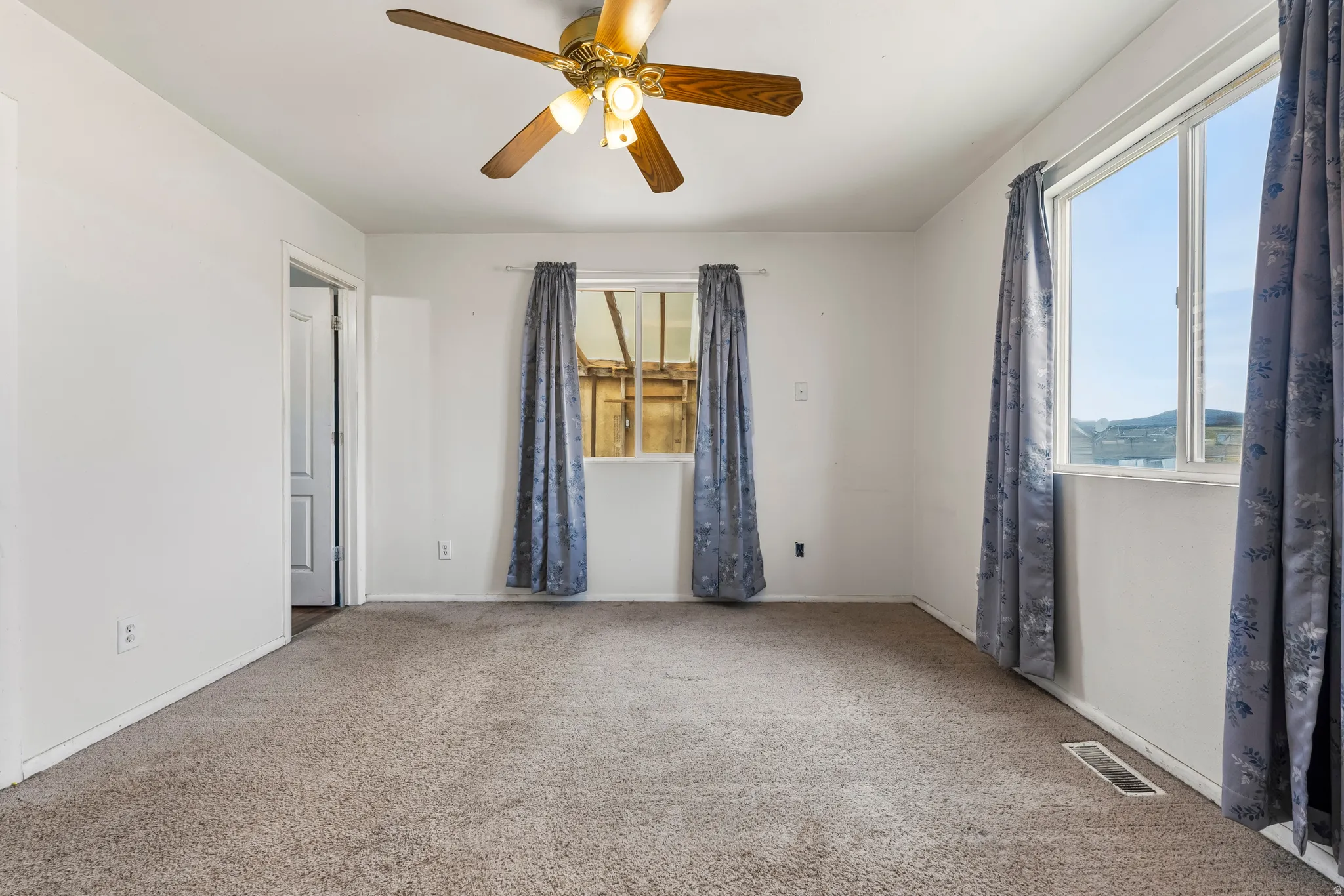 Spare room featuring a ceiling fan and carpet