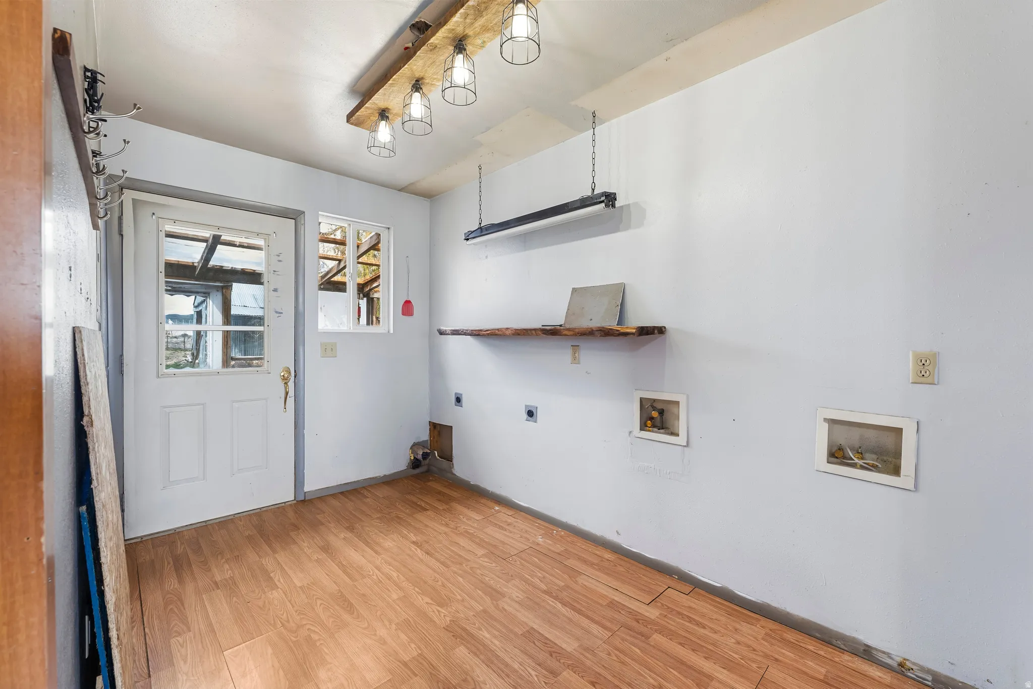 Laundry area with light wood-style floors, hookup for an electric dryer, and hookup for a washing machine