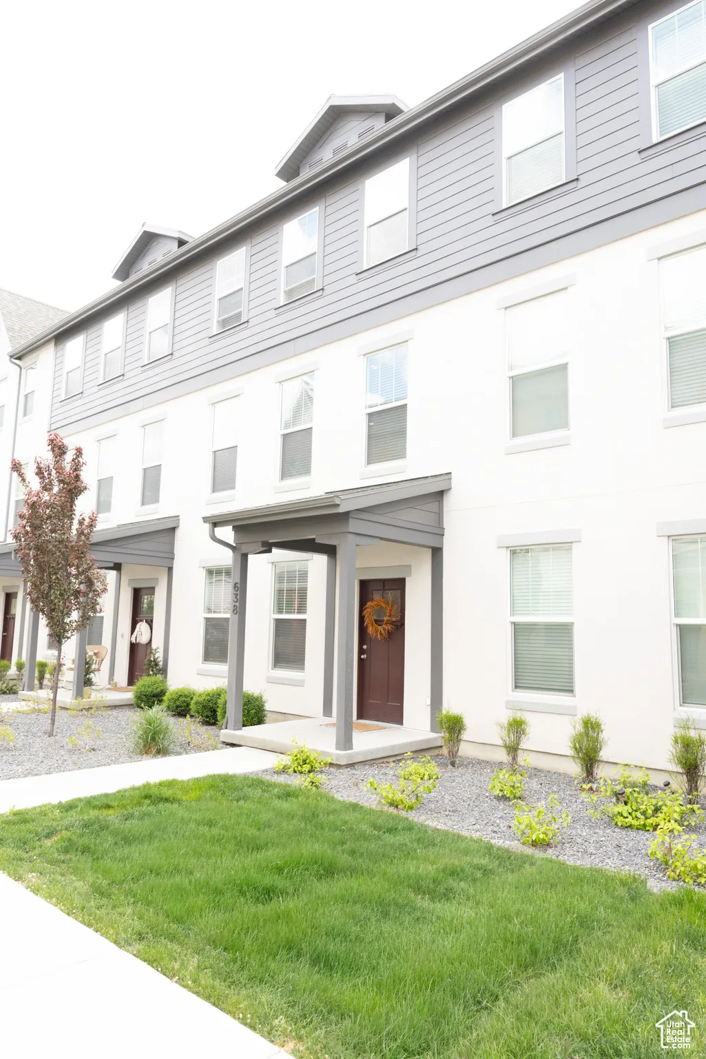 View of front facade with a front yard and stucco siding