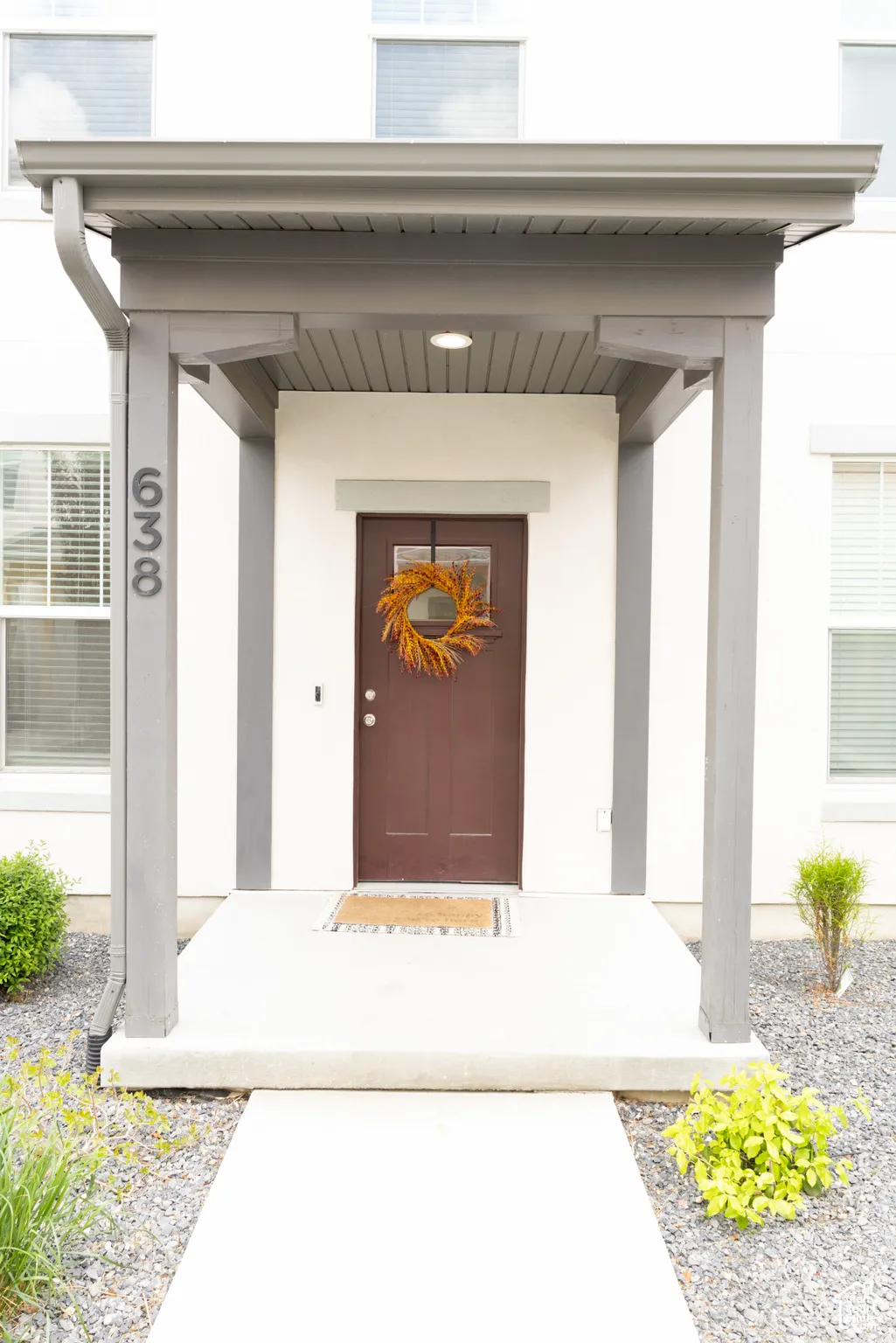 Doorway to property featuring a porch and stucco siding