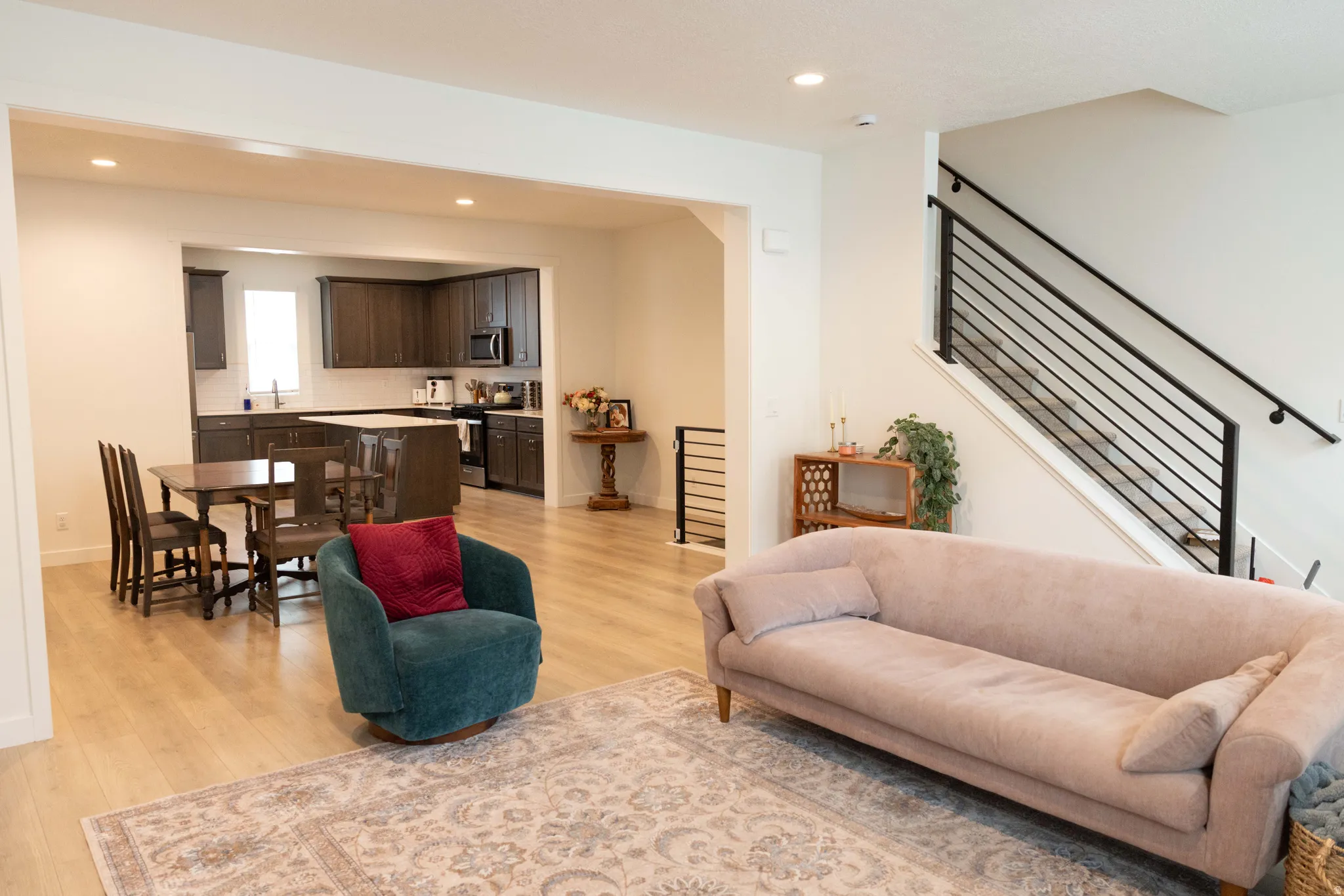 Living area with light wood-type flooring and recessed lighting