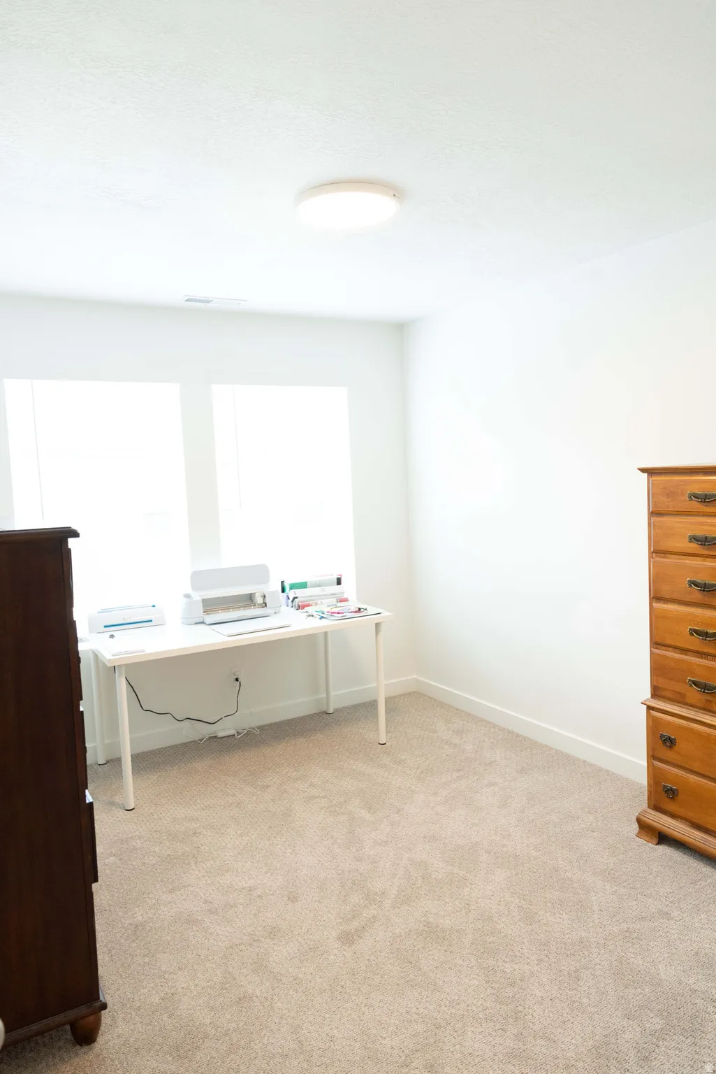 Home office with light colored carpet and baseboards