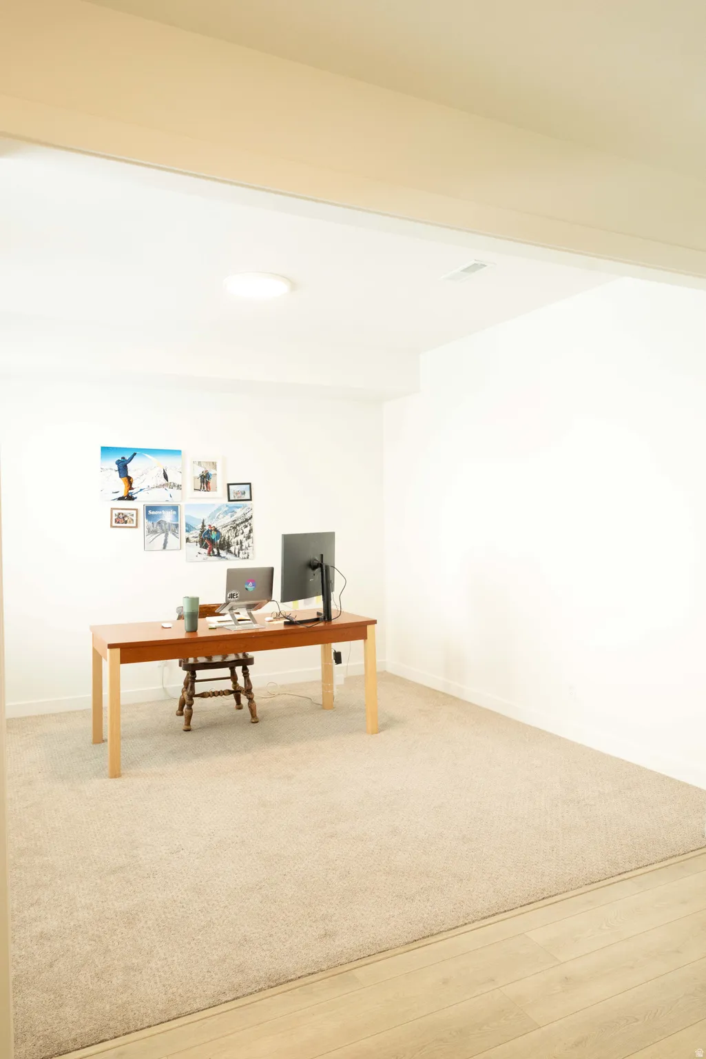 Office space featuring light wood-style flooring and light carpet