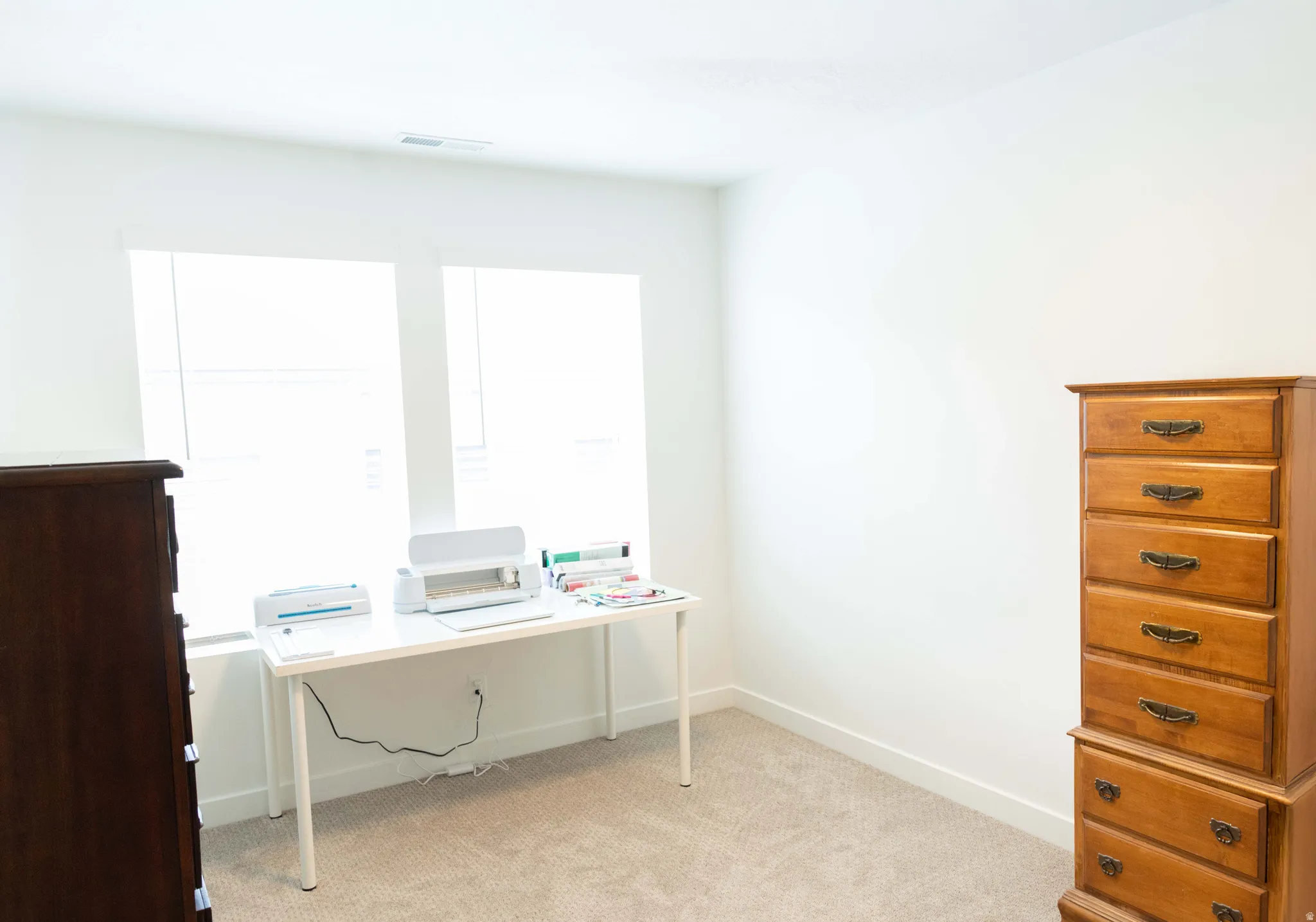 Home office with light carpet and baseboards