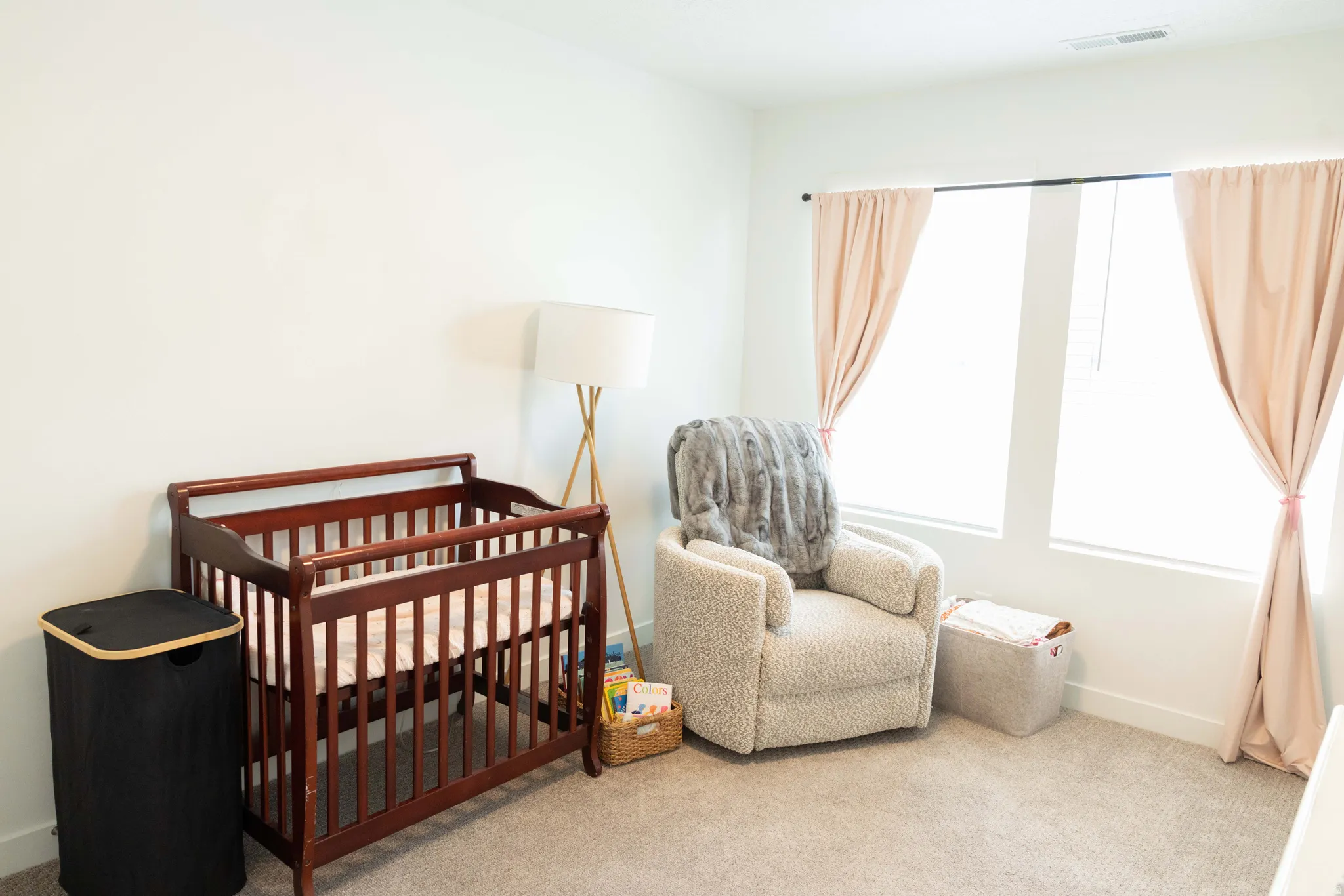 Bedroom with a nursery area and light carpet
