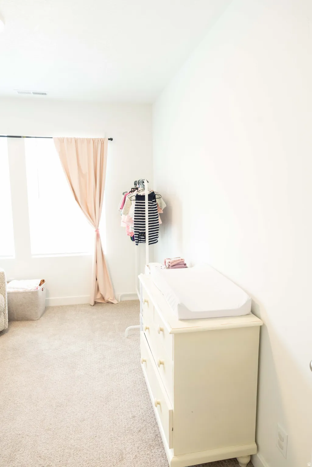 Bedroom featuring light carpet and baseboards