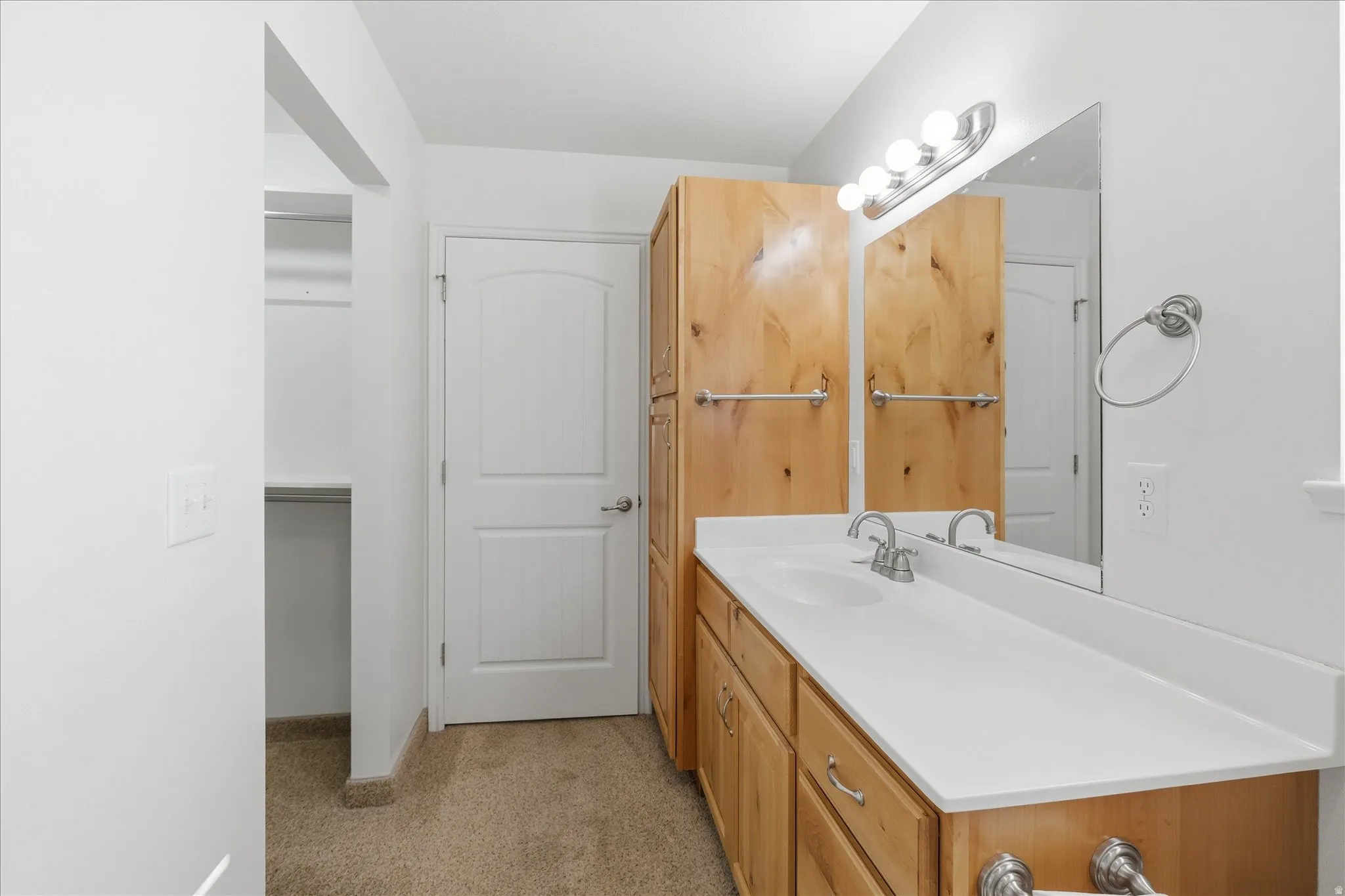 Bathroom with vanity and light carpet