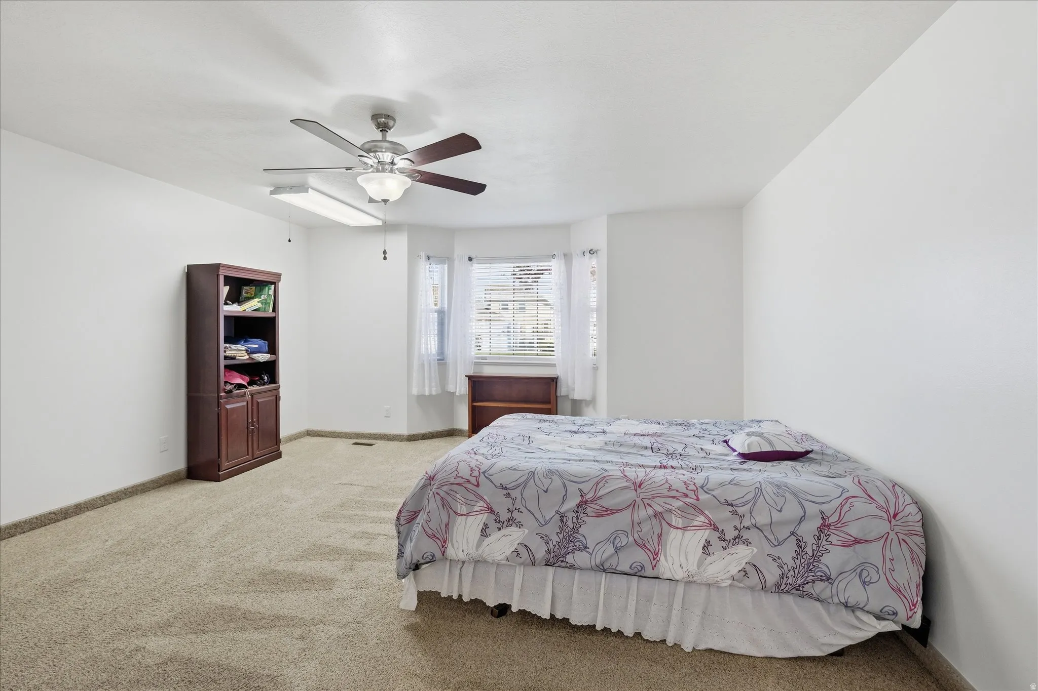 Bedroom featuring light colored carpet and a ceiling fan