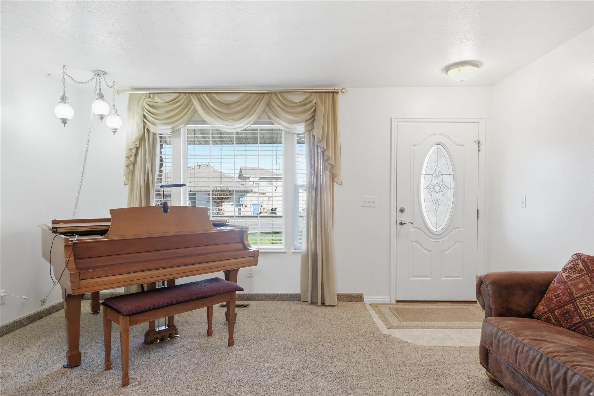 Entrance foyer featuring light colored carpet and baseboards