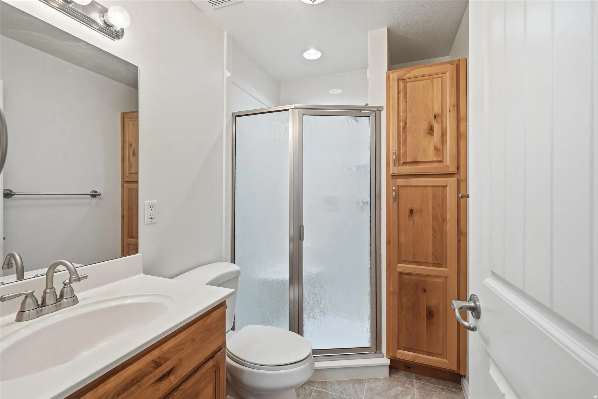 Bathroom #2 featuring storage cabinets, walk in shower, and vanity