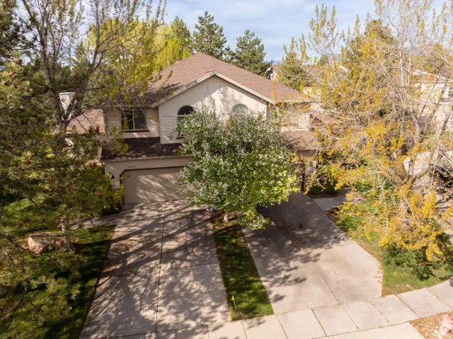 View of front facade with roof with shingles, a garage, and concrete driveway