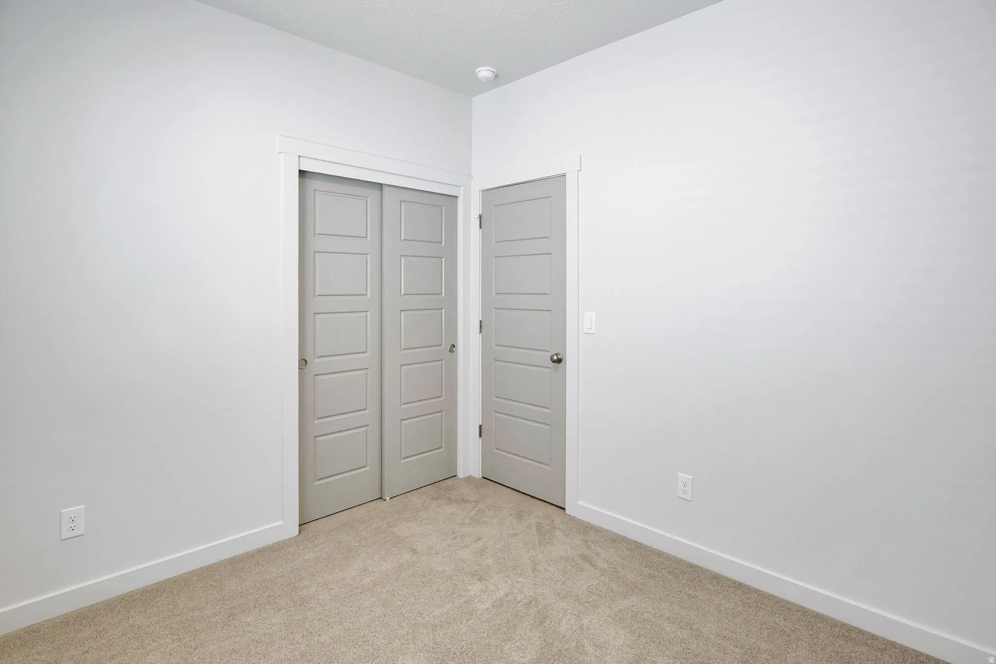 Unfurnished bedroom featuring a closet and light carpet