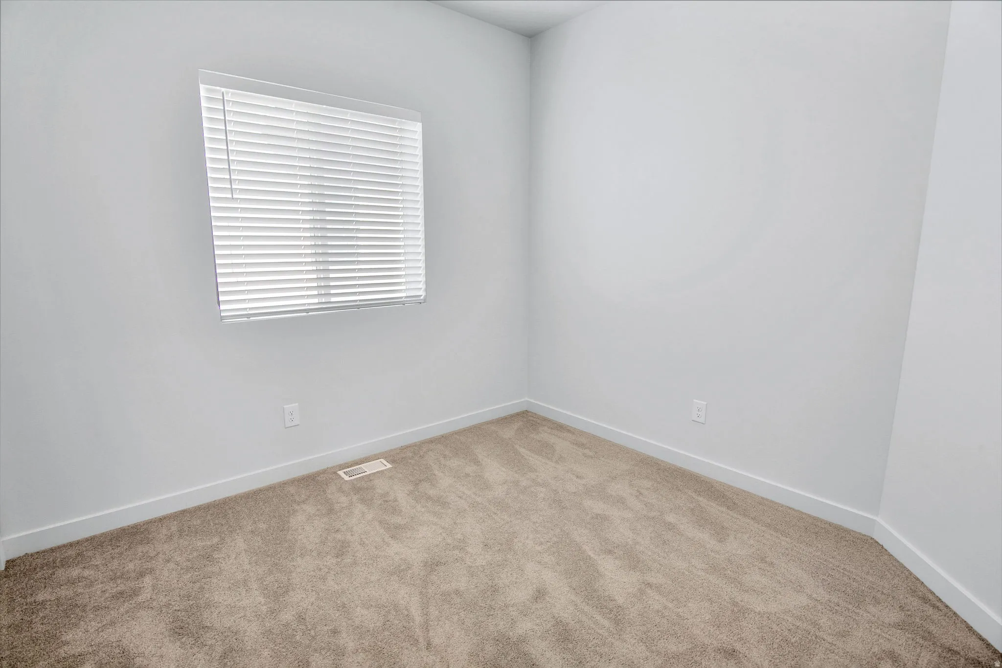Unfurnished room with light colored carpet and baseboards
