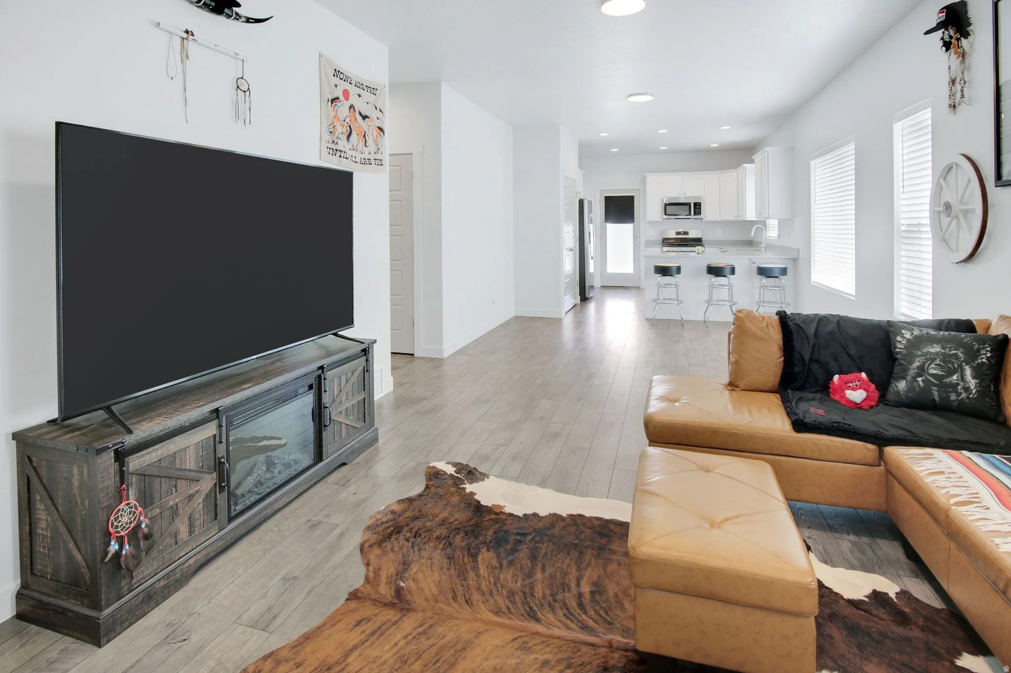 Living area featuring light wood finished floors, healthy amount of natural light, and recessed lighting