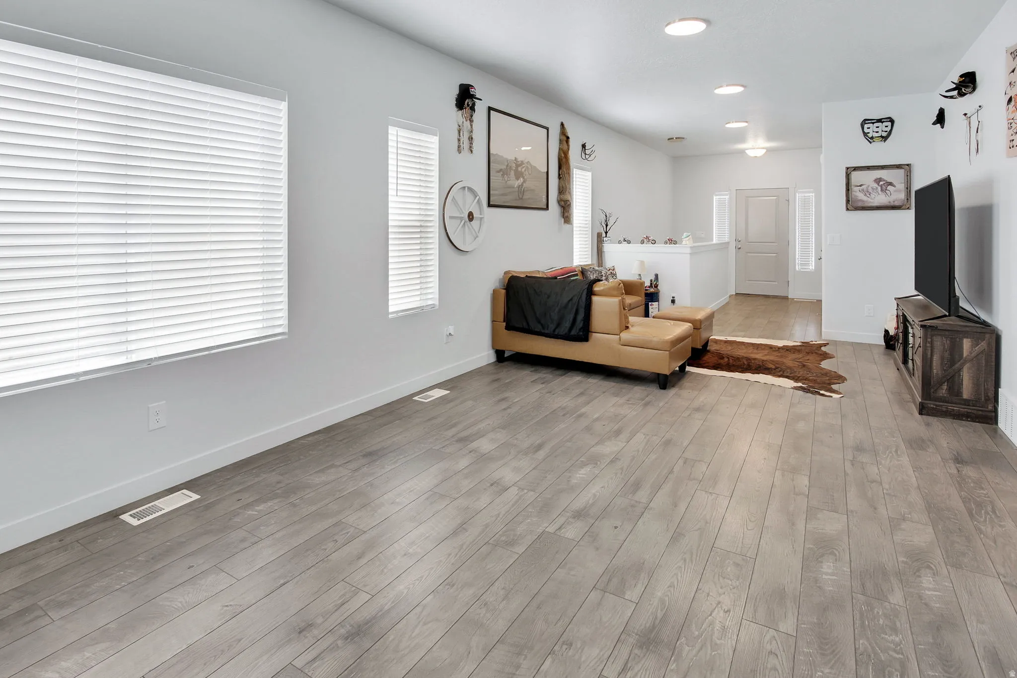 Living room with light wood-type flooring and recessed lighting