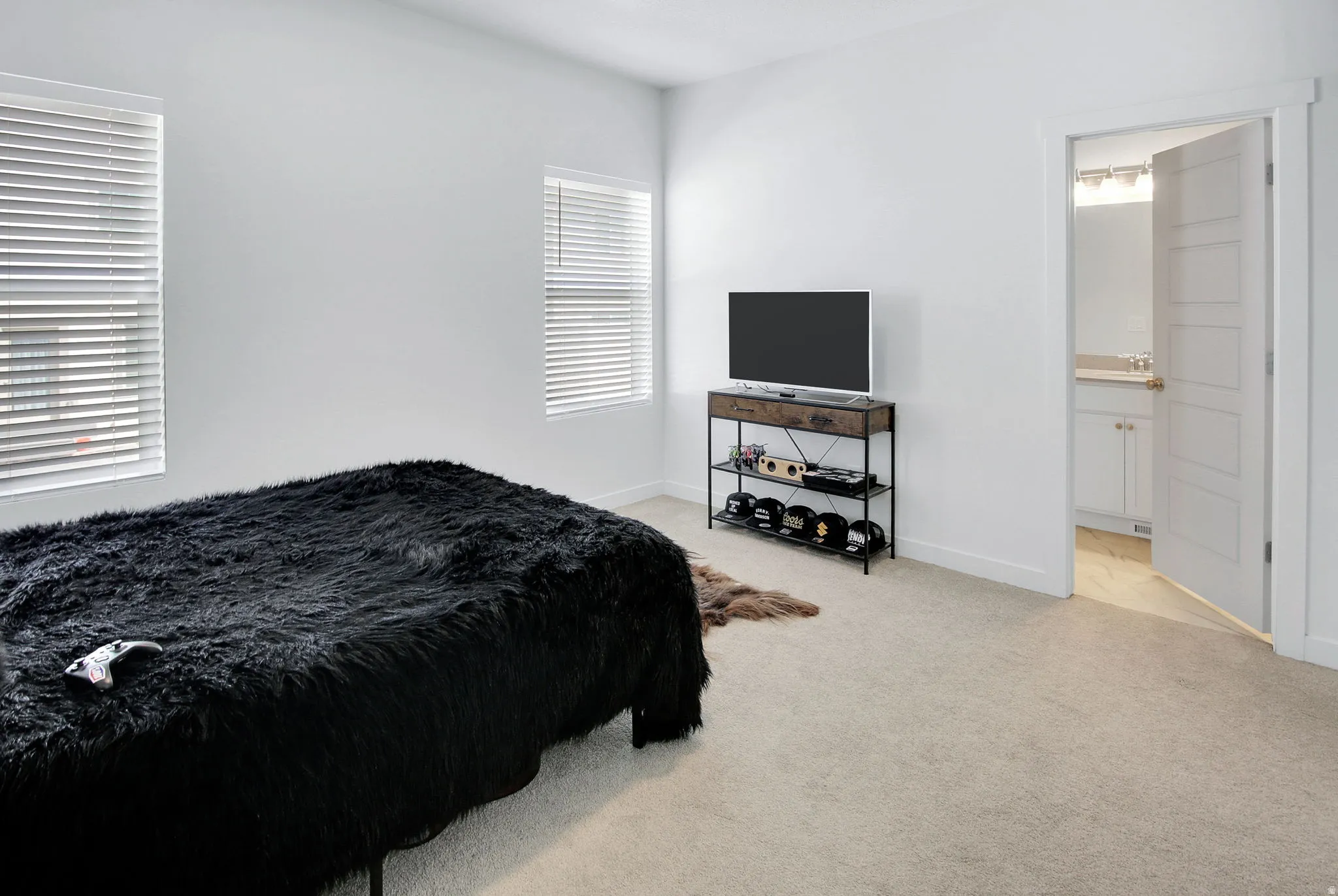 Bedroom with light carpet and ensuite bath