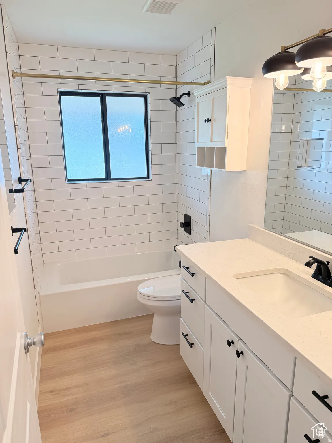 Full bath featuring vanity, light wood-style floors, and shower / washtub combination