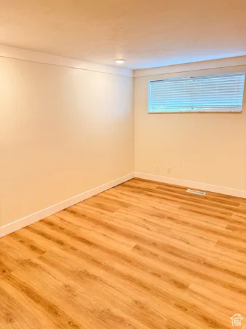 Empty room with wood finished floors and a textured ceiling
