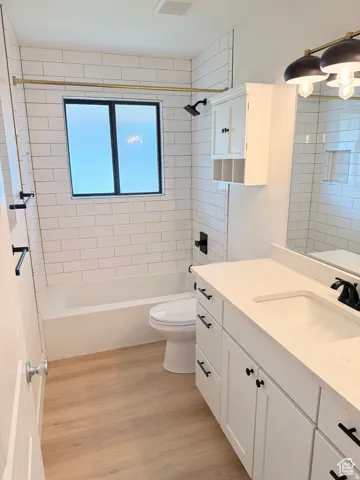 Full bath featuring vanity, light wood-style floors, and shower / washtub combination