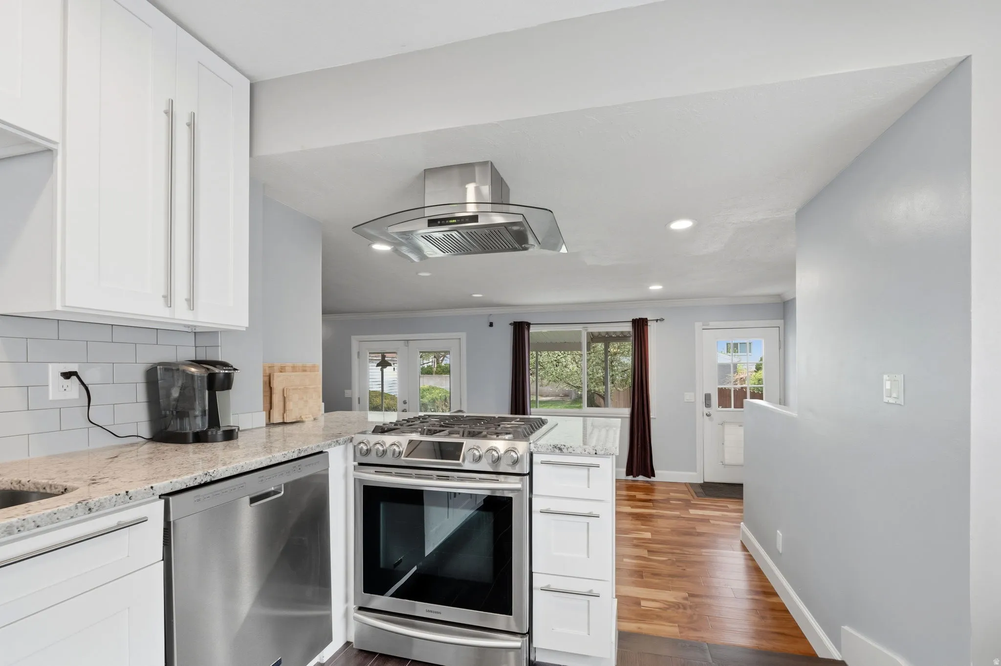 Kitchen featuring white cabinets, light stone counters, a peninsula, stainless steel appliances, and recessed lighting