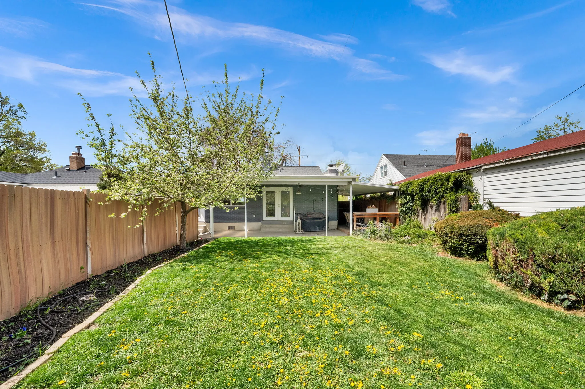 Rear view of property featuring a fenced backyard, french doors, and a patio area