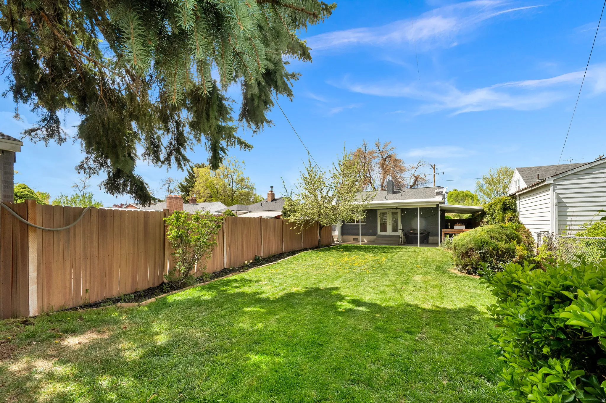Fenced backyard featuring a sunroom