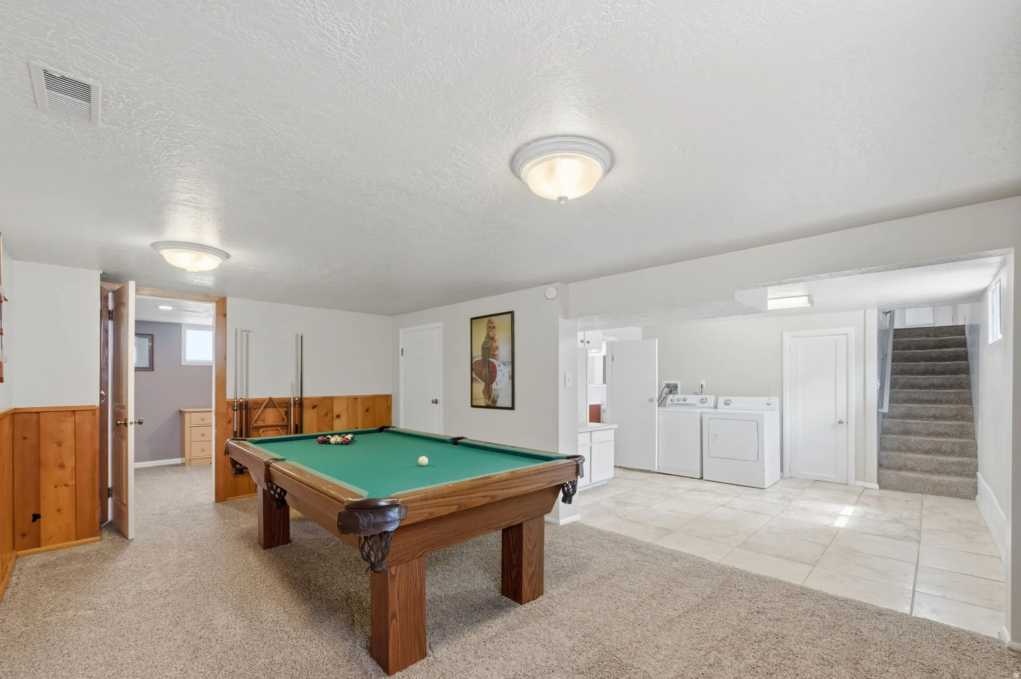 Recreation room with light colored carpet, billiards, a textured ceiling, independent washer and dryer, and wood walls