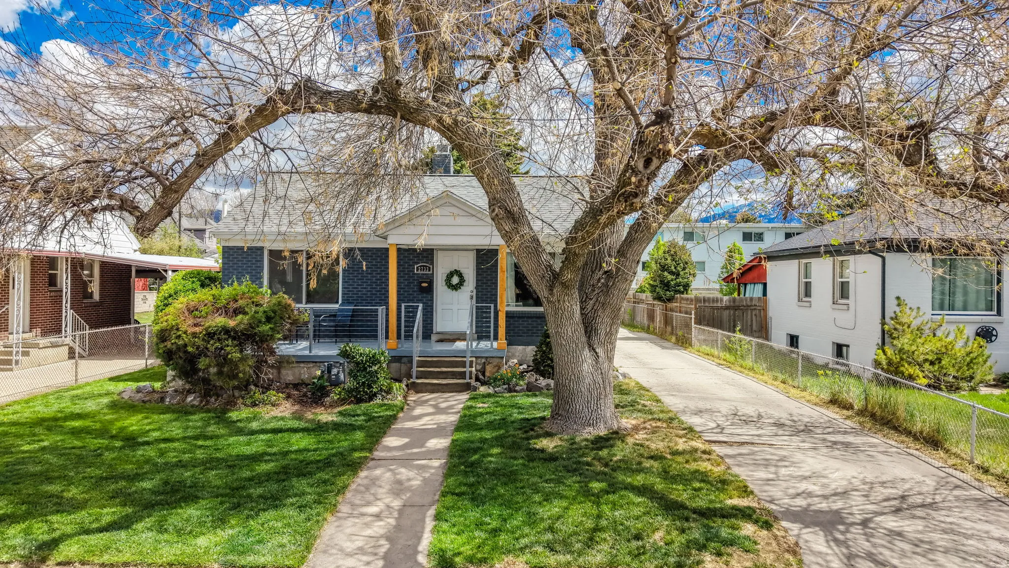 Bungalow-style house featuring brick siding, covered porch, and driveway
