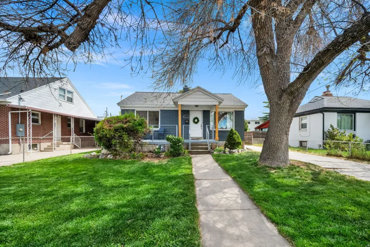 Bungalow featuring brick siding, a porch, and a chimney