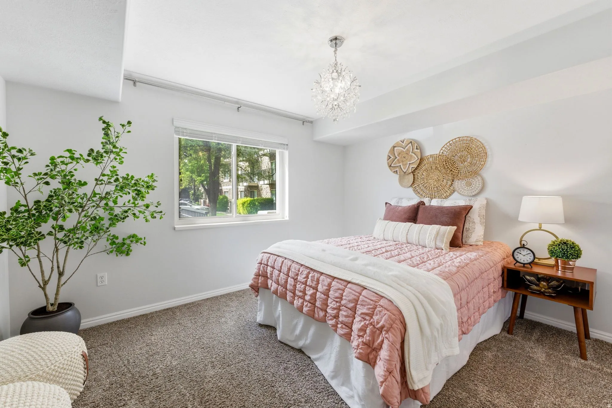 Bedroom with suspended lighting and dark colored carpet
