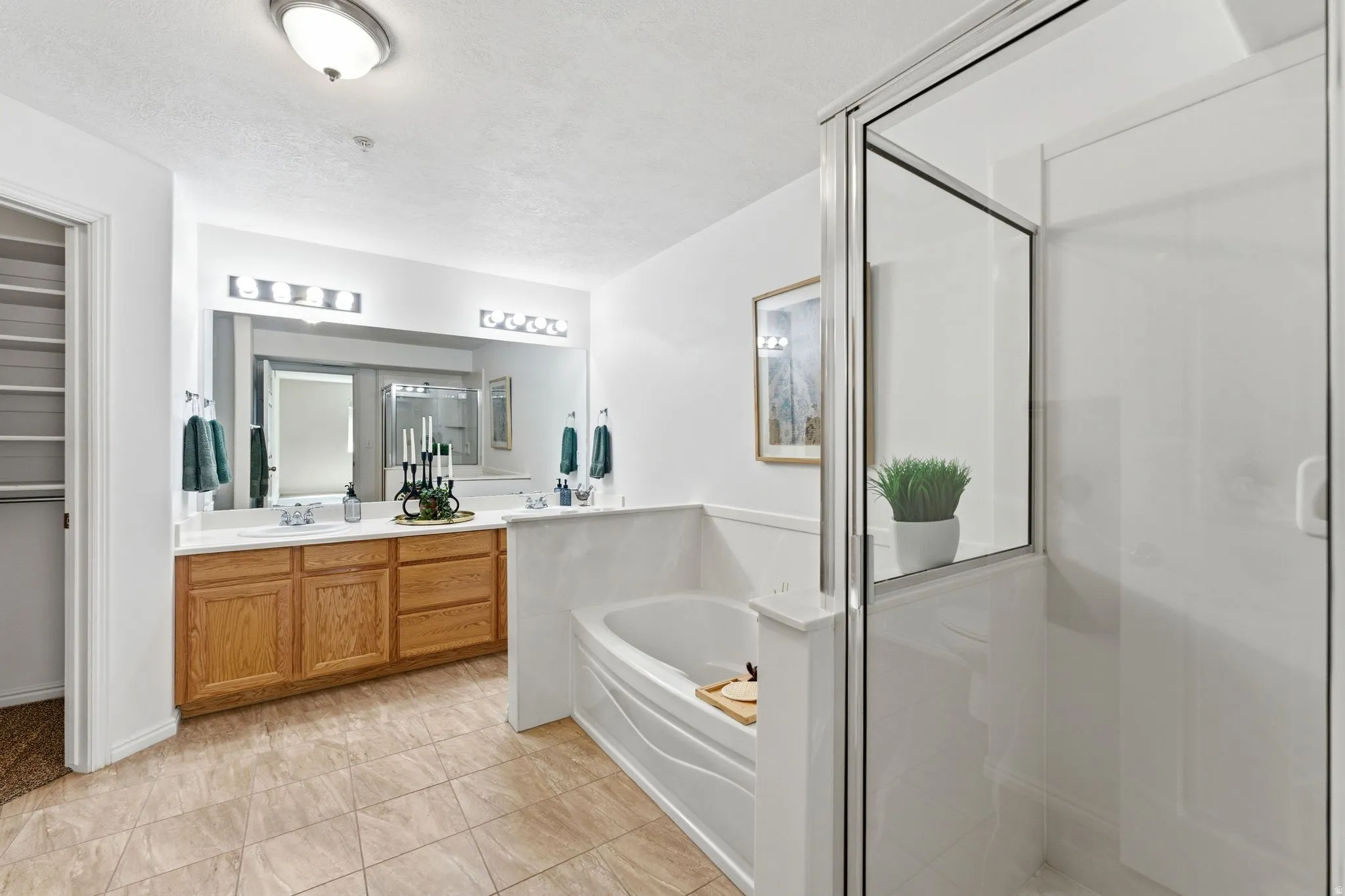 Full bath with vanity, a stall shower, a garden tub, and a textured ceiling
