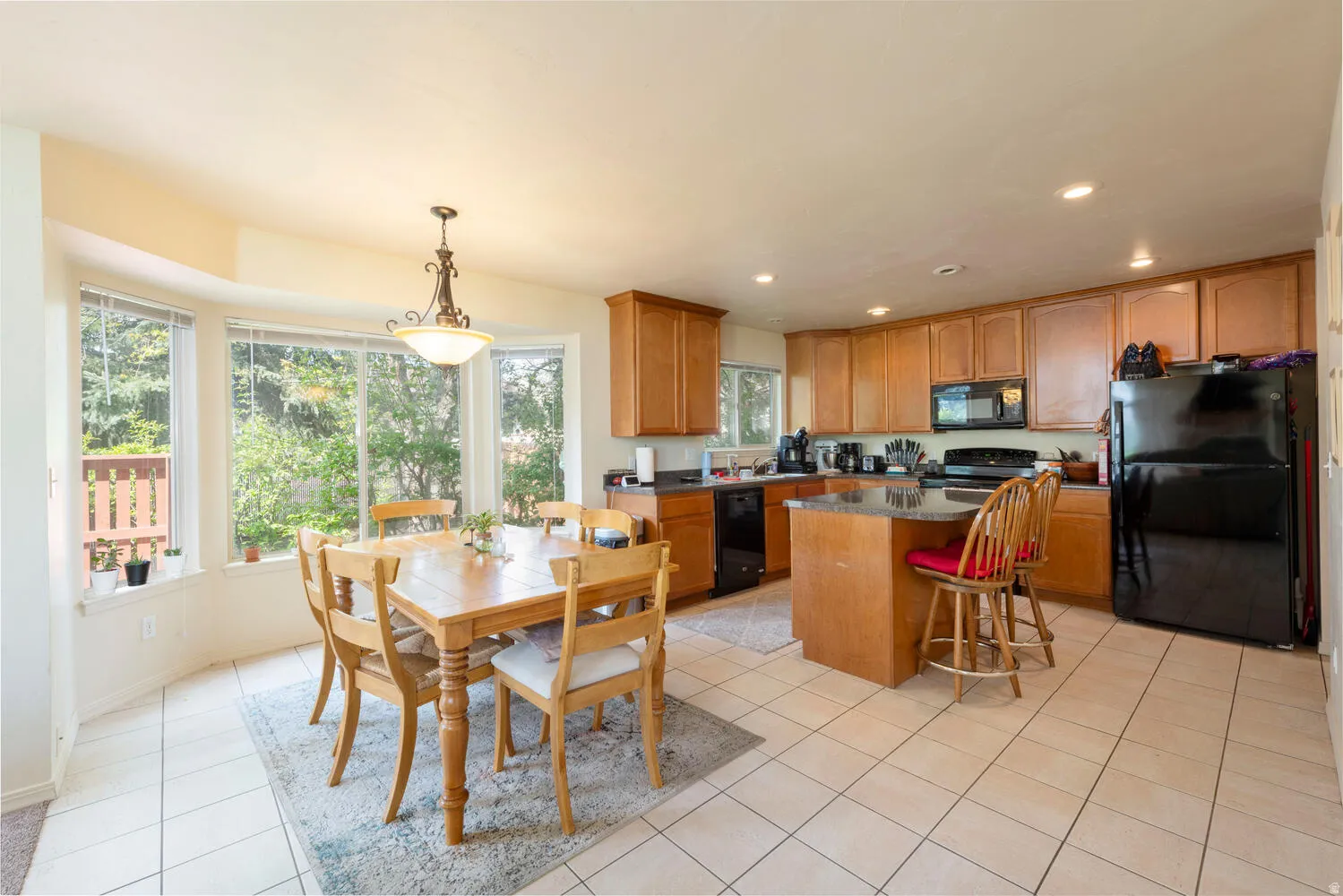 Kitchen featuring black appliances, a center island and a breakfast bar