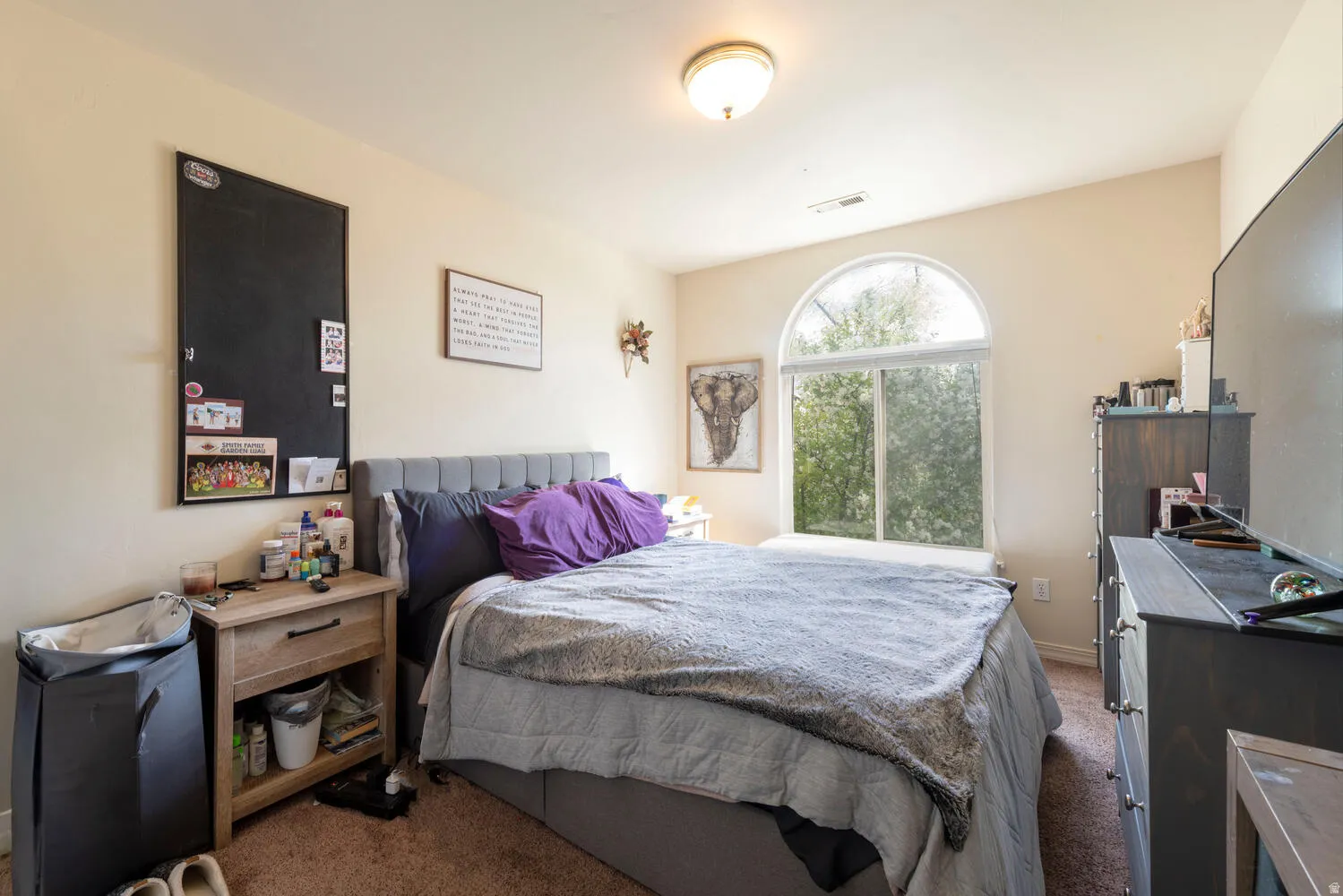 Bedroom with dark colored carpet and baseboards