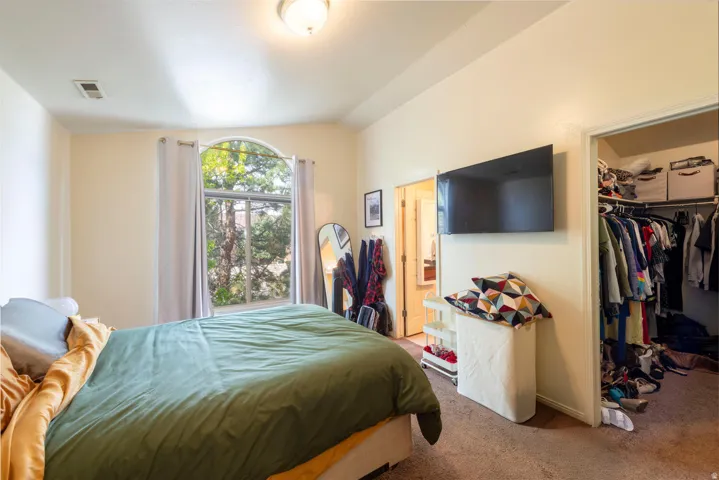 Primary bedroom featuring vaulted ceiling, and a spacious closet