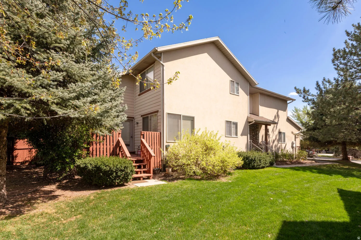 Rear view of house with a yard and stucco siding