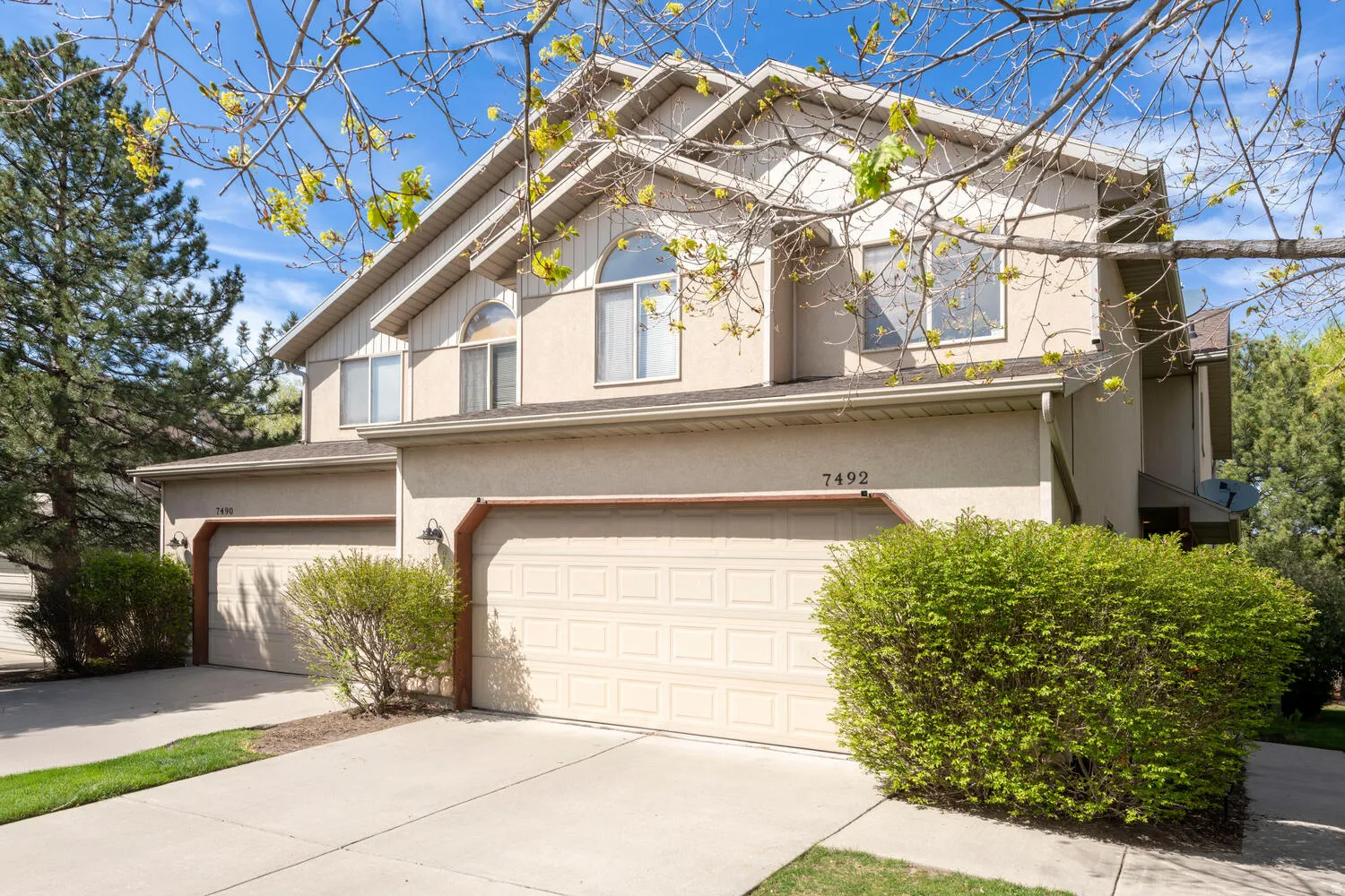 Traditional-style house with concrete driveway, an attached garage, and stucco siding