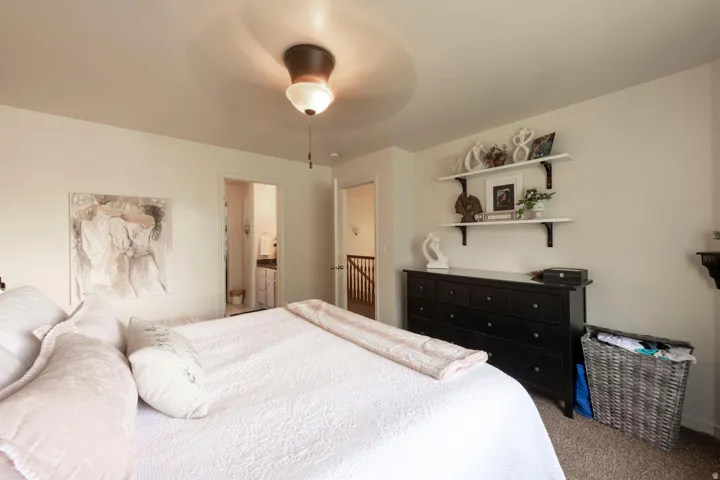 Another view of the primary bedroom with bathroom and landing in the background