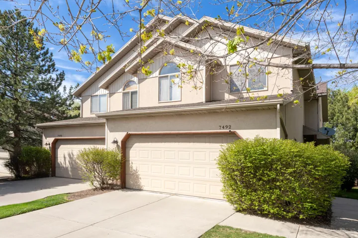 Traditional-style house with concrete driveway, an attached garage, and stucco siding
