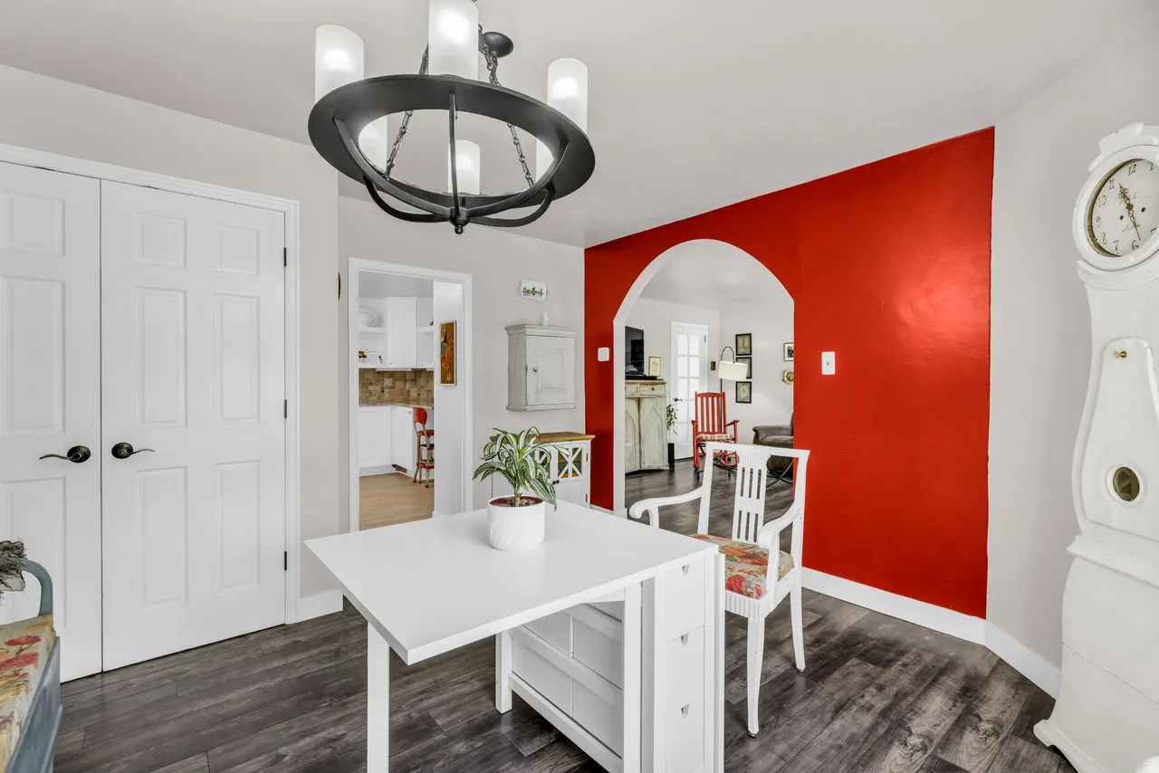 Dining space featuring arched walkways, dark wood-style floors, and suspended lighting