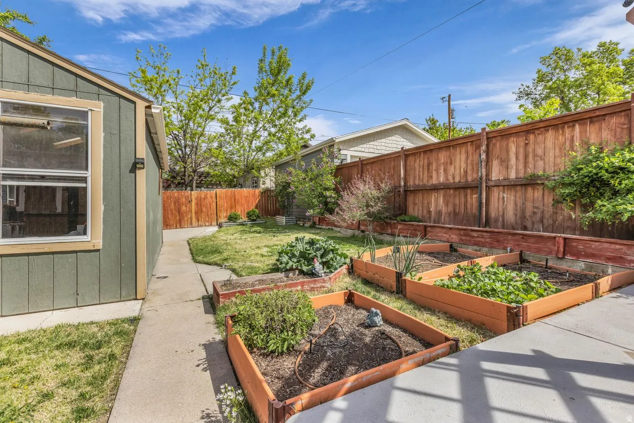 Fenced backyard featuring a garden