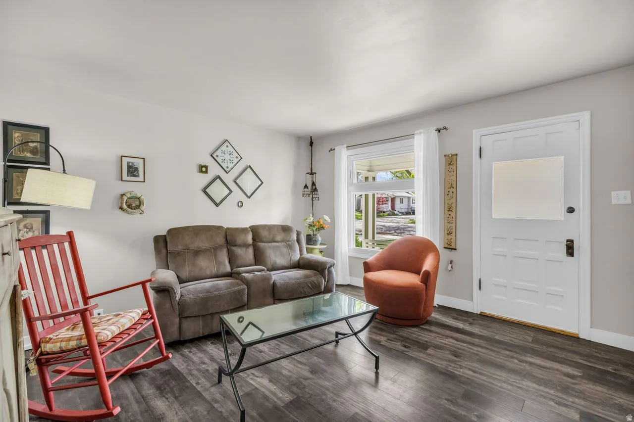 Living room featuring dark wood finished floors and baseboards