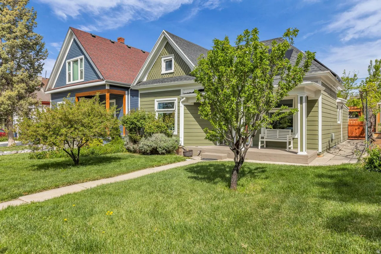 View of front of house featuring a front yard, roof with shingles, and a porch