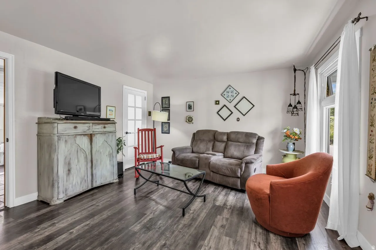 Living area featuring dark wood-style flooring and baseboards