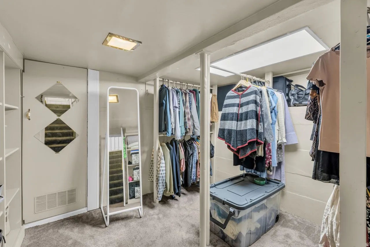 Walk in closet featuring light colored carpet