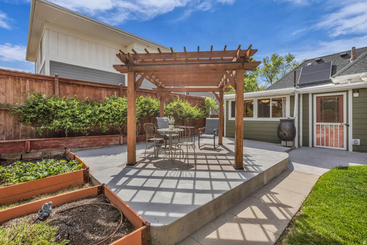 Fenced backyard with a patio area, a pergola, and a garden
