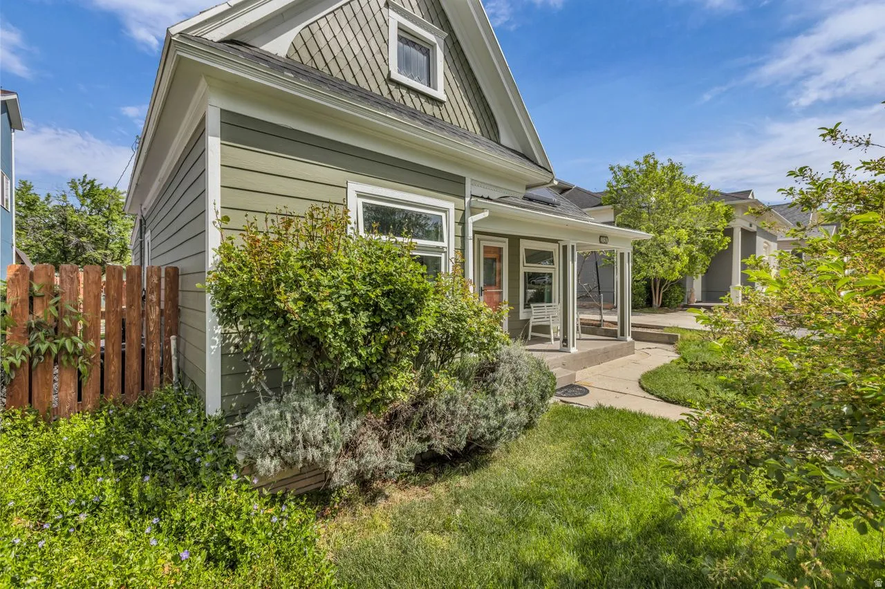Back of property featuring a sunroom and a shingled roof