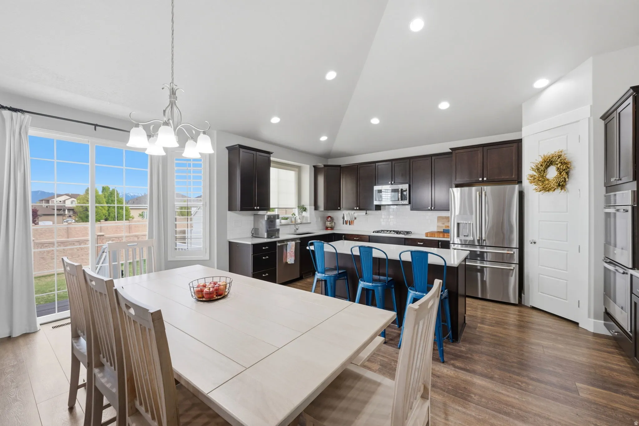 Dining space with vaulted ceiling, a chandelier, and dark wood finished floors