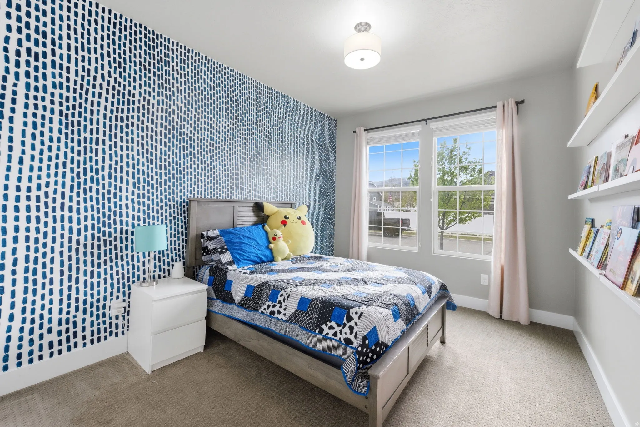Carpeted bedroom with an accent wall and baseboards