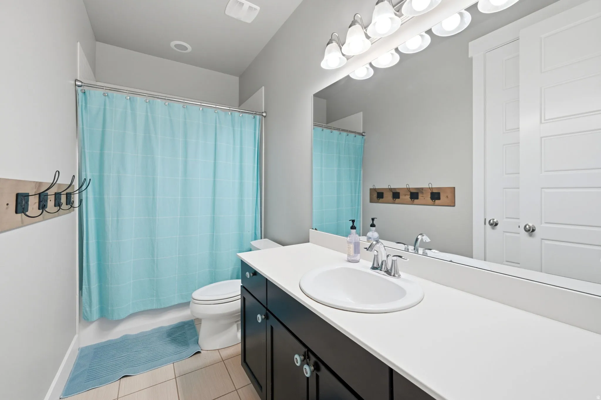 Full bathroom with vanity, light tile patterned floors, and shower / bath combo